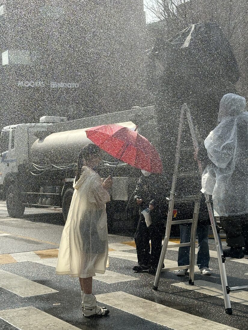 촬영 현장에서 강우기와 함께 작업 중인 살수차